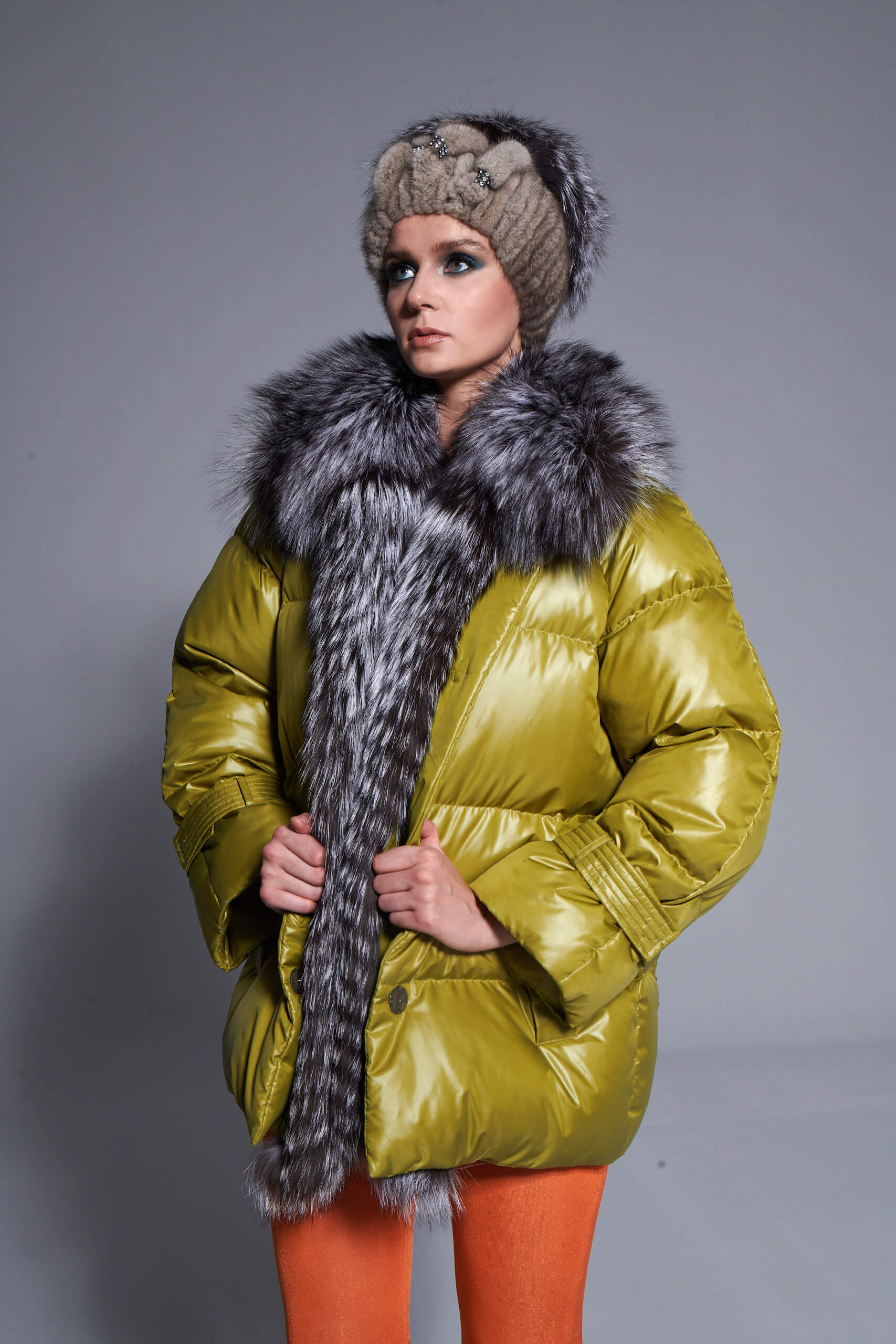 a woman in a green down coat with fox fur collars