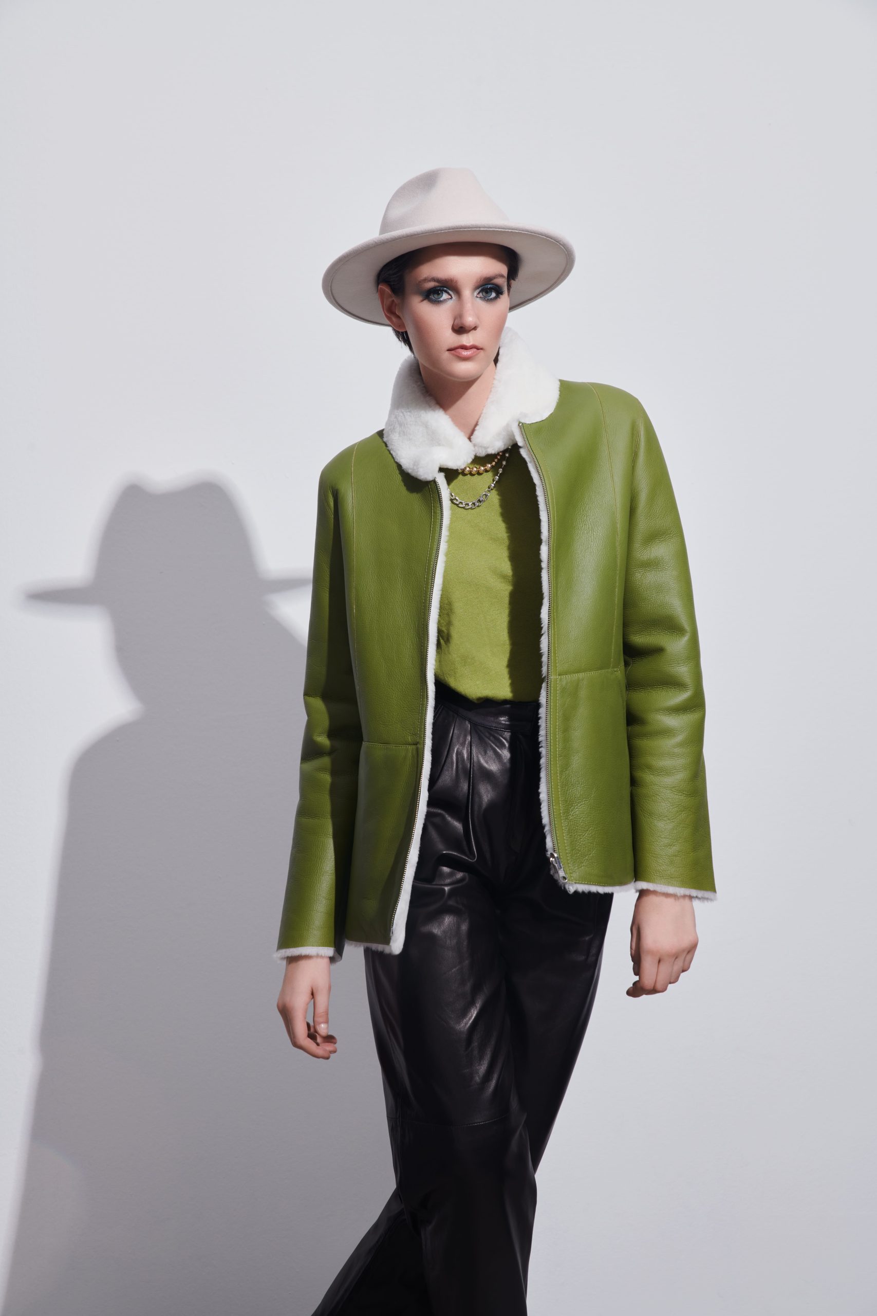 Woman with a white hat an a green and white shearling coat