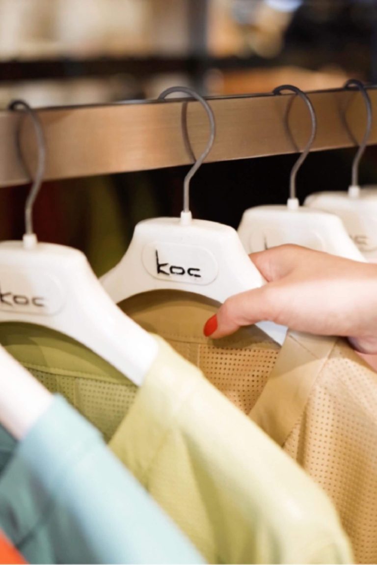 a hand holding a white swinger with a few shirts on it